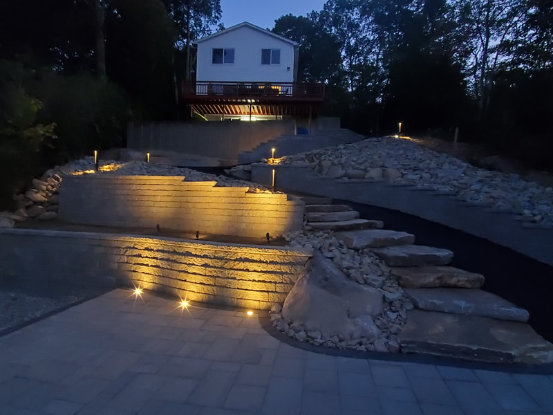 Retaining wall installed, natural stone steps, landscaping lighting, in a large patio project near Glastonbury CT