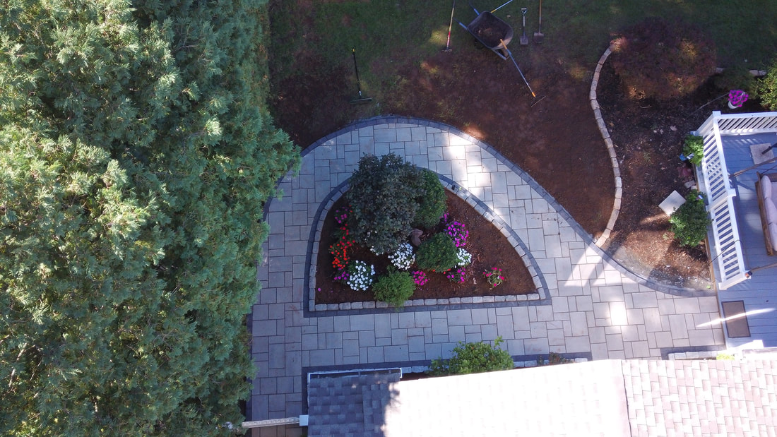 Blue 60 pavers pathway and landscaping with flowers, shrubs and wood chips ground cover.