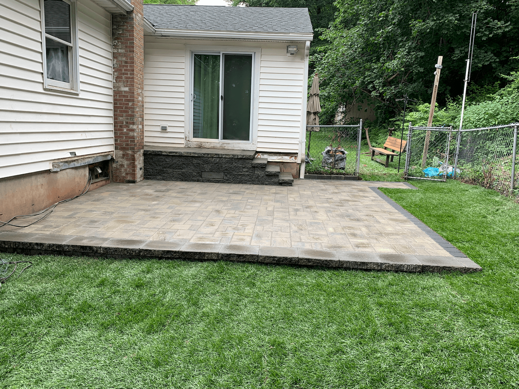 Well kept lawn with paver patio and steps