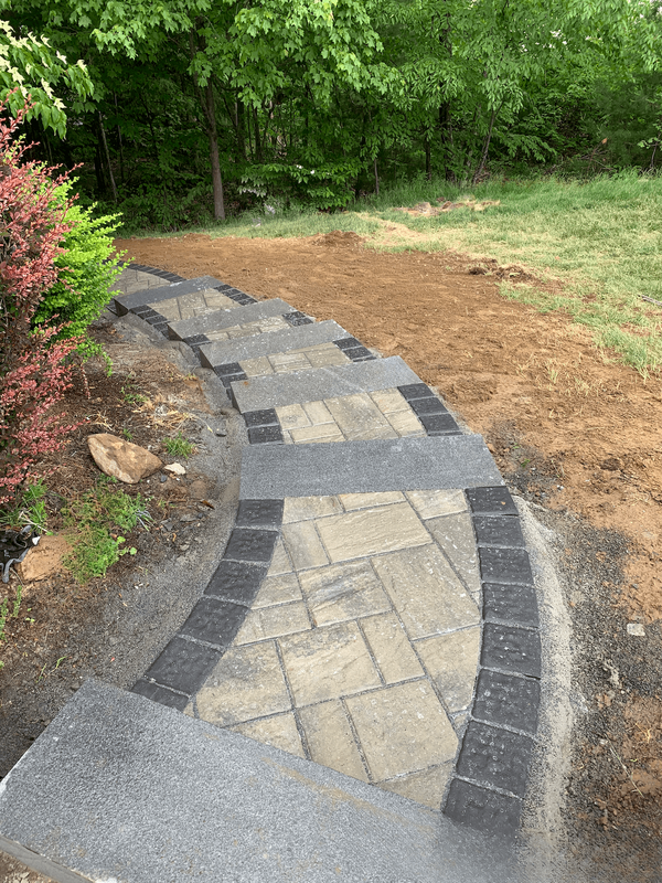 Tan pavers pathway with concrete steps and dark pavers border
